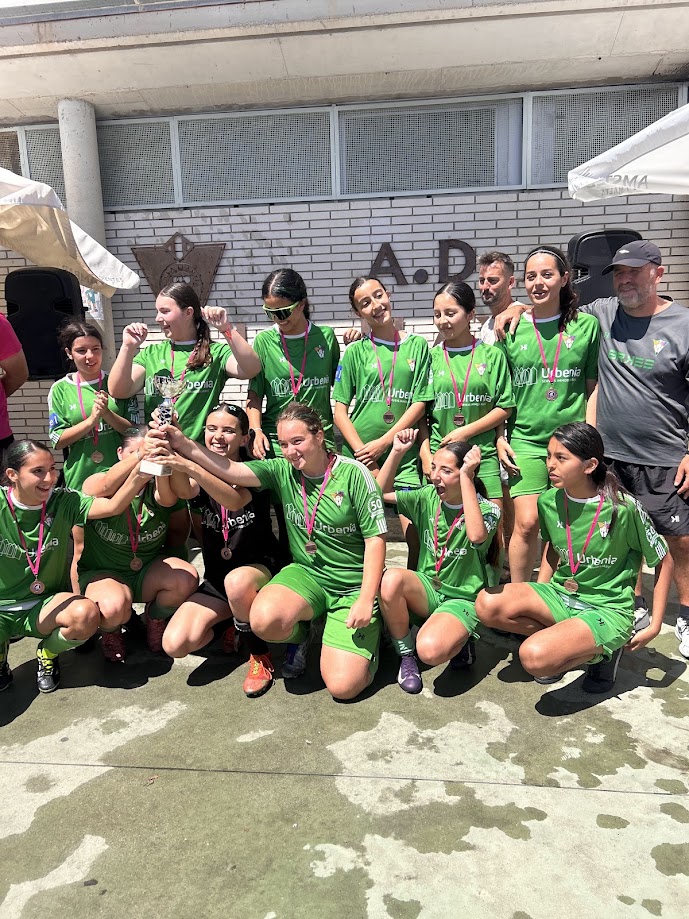 Equipo celebrando con el trofeo y medallas